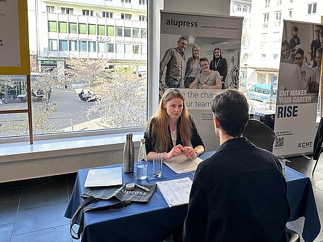 [Translate to English:] HR-Mitarbeiterin im Gespräch mit einem Kandidaten beim Job Speed Dating der UniBz